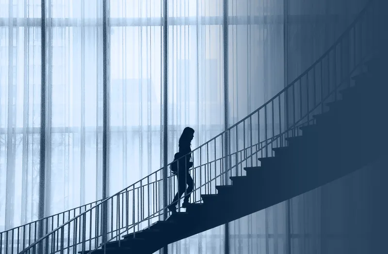 Campagnebeeld van USG Executive Search met een vrouwelijke professional die de trap oploopt.